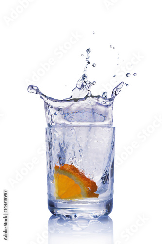 Splash in glass of blue water with orange slice