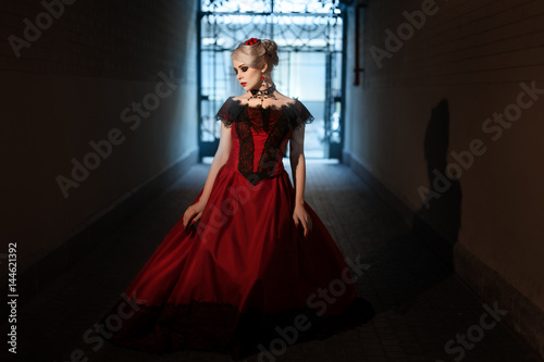 Woman in a Victorian manner, dressed in a red dress.