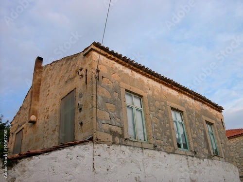 Altes Wohnhaus aus hellem Naturstein und Bruchstein in Beige und Naturfarben am Abend in der Altstadt von Alacati bei Cesme am Ägäischen Meer in der Provinz Izmir in der Türkei photo