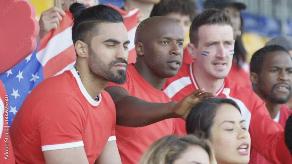 Crowd of spectators watching sports game in stadium cheering on their team Crowd of spectators watching sports game in stadium cheering on their team