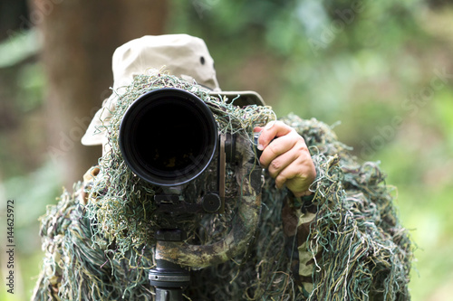 an ornithologist wear hide suit for focusing the bird in rain forest