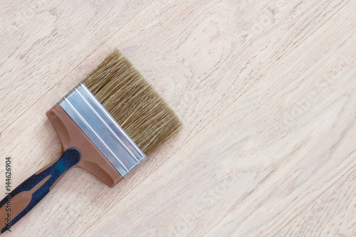 Paint brush on wooden floor with copy space for text