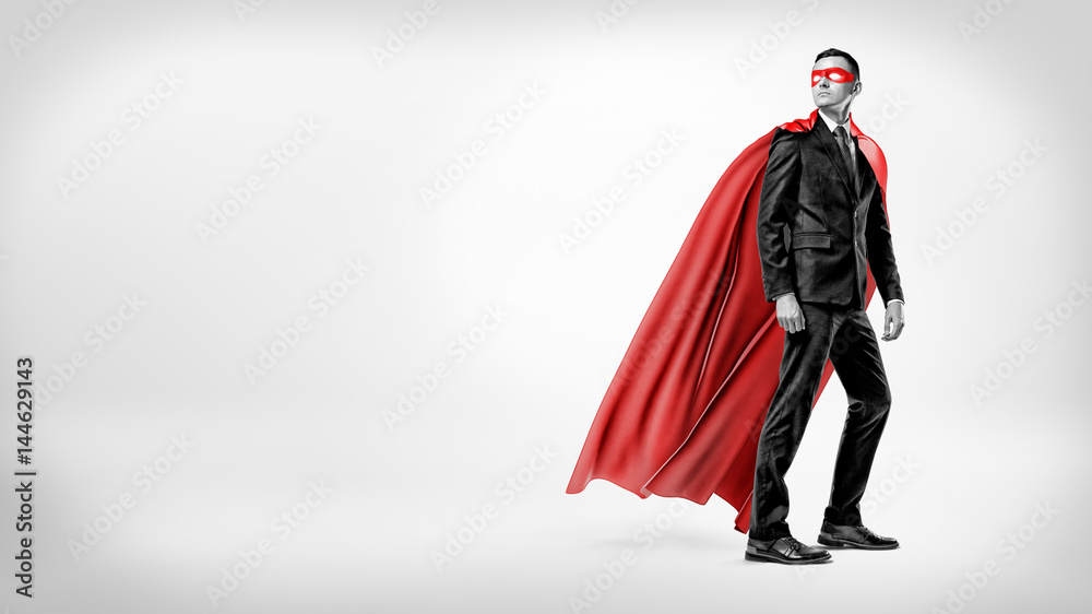 A businessman in a flowing red superhero cape and a mask looking over his shoulder on white background.