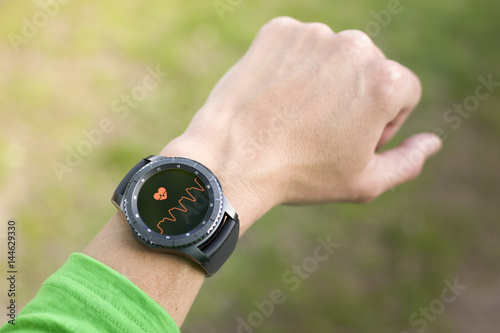 .Generic design smartwatch. Touching screen illustrative interface. Heart rate during jogging. Pulse monitoring