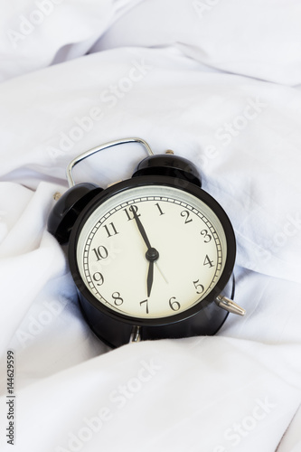 Vintage retro alarm clock on untidy bed