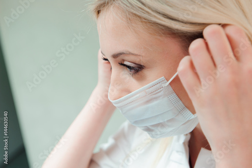 adult dentist puts a protective mask on her mouth