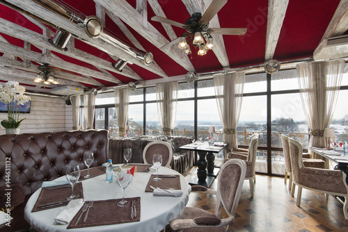 Fotografie spacious restaurant with large panoramic windows, a leather sofa, elegant chairs