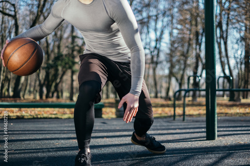 Man dribbling basketball in park, Minsk, Belarus