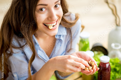 Closeup view from above of a woman eating brasil nuts with healthy food on the background photo