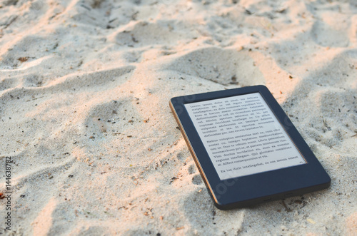 Obraz na plátně E-book reader laying on the beach sand