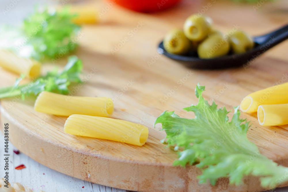 Italian tortiglioni pasta ready to cooking on kitchen board. Italian tortiglioni pasta ready to cooking on kitchen board.