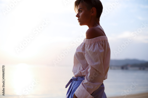 Sunny girl is posing on near the sea