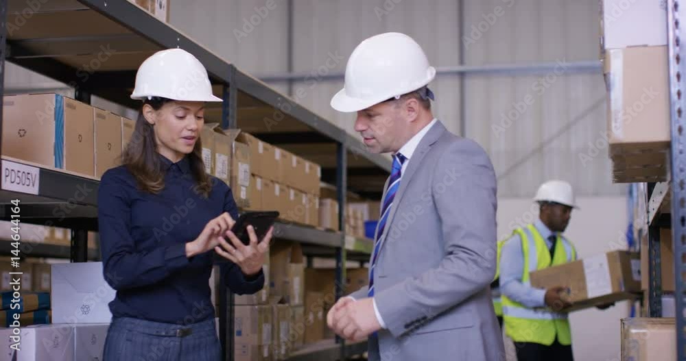 Mixed ethnicity management team in industrial warehouse shake hands on a deal Mixed ethnicity management team in industrial warehouse shake hands on a deal