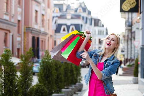 Smiling girl with shopping bags. Walks the streets of the city