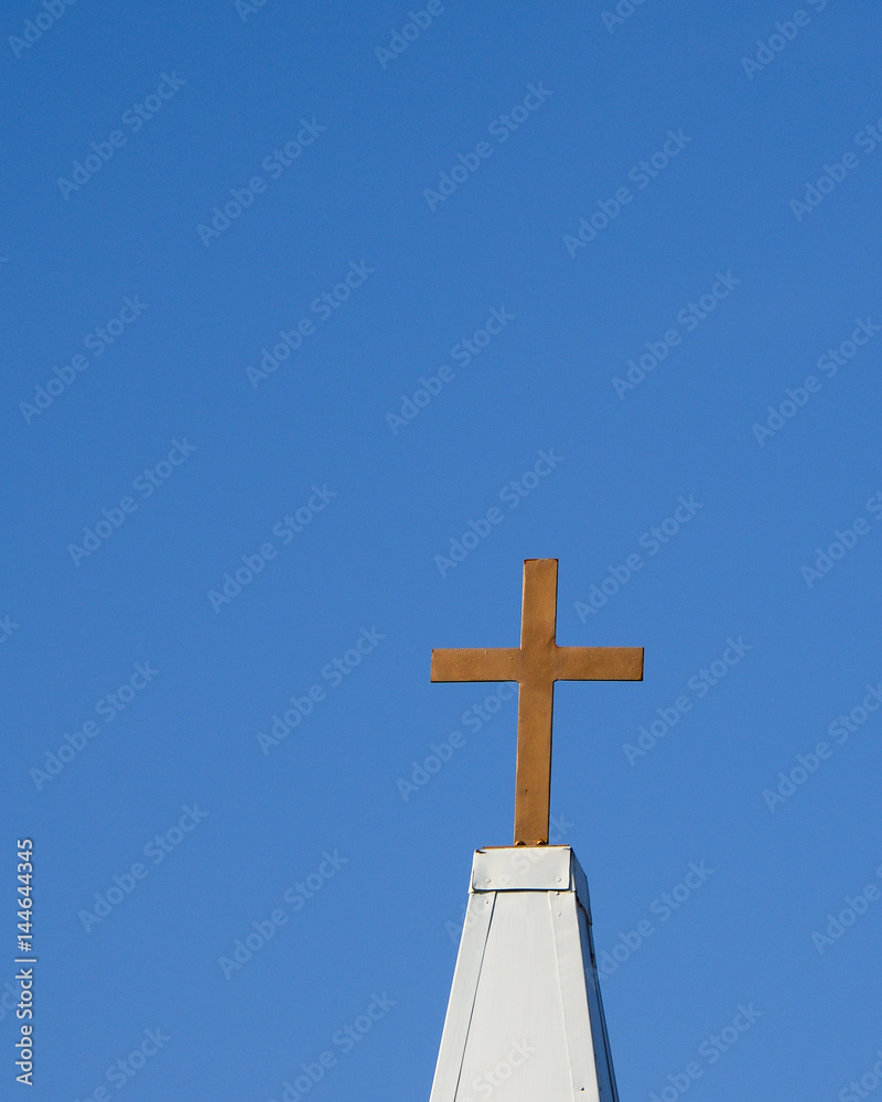 Gold metal cross against a deep blue background