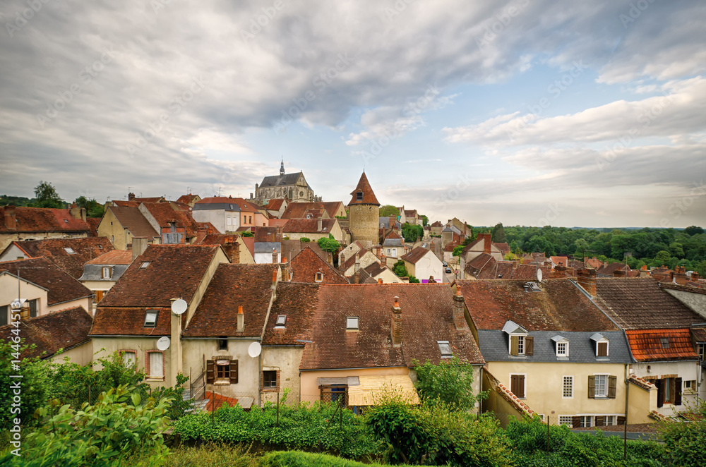 View of the small town of Saint-Florentin. Burgundy. France. Tiled roofs of houses are visible. In the background is St. Florentine's Cathedral.