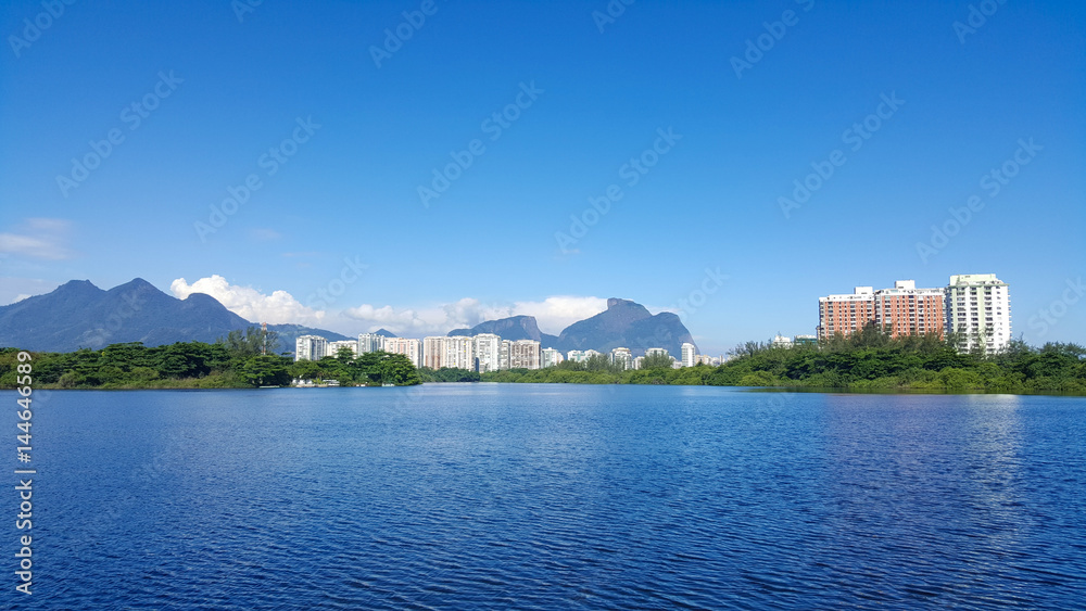View of lagoon in Barra da Tijuca with mountains and buildings in the background in Rio de Janeiro Brazil