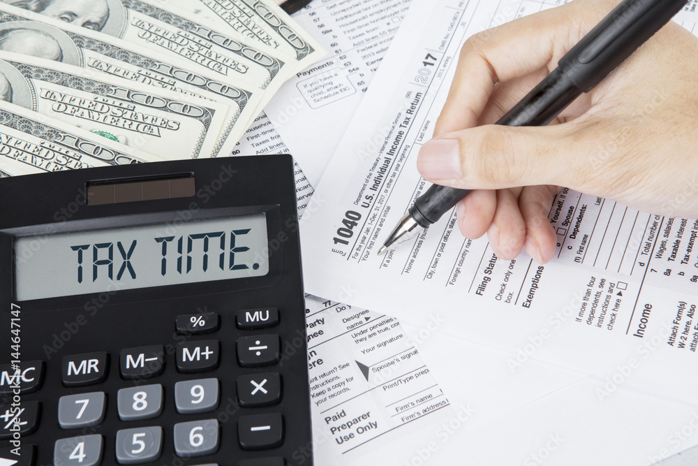 Hands of businessman filling out tax forms Hands of businessman filling out tax forms