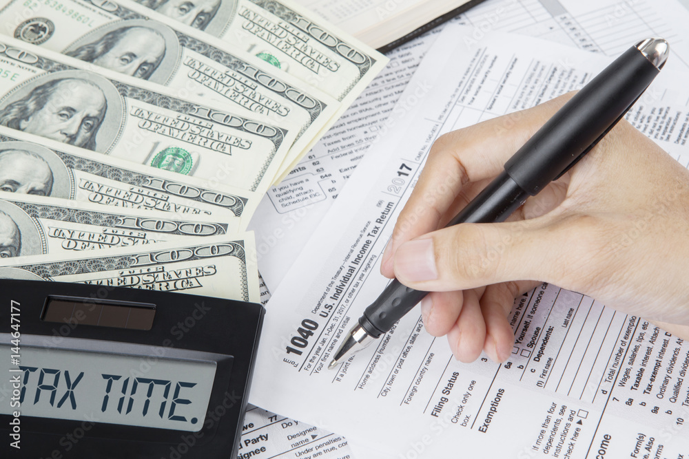 Obraz premium Hands of worker writes on a tax form
