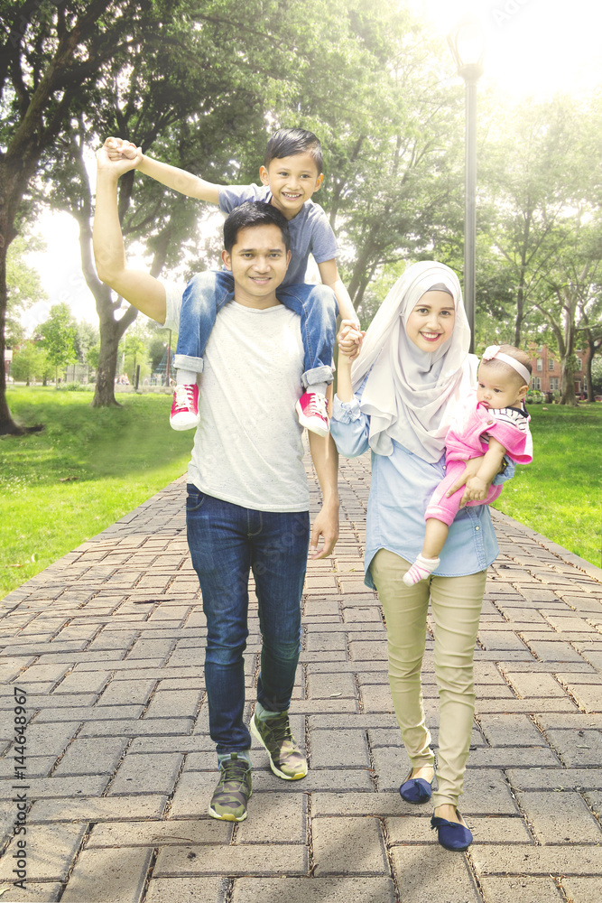 Muslim family walk in park way