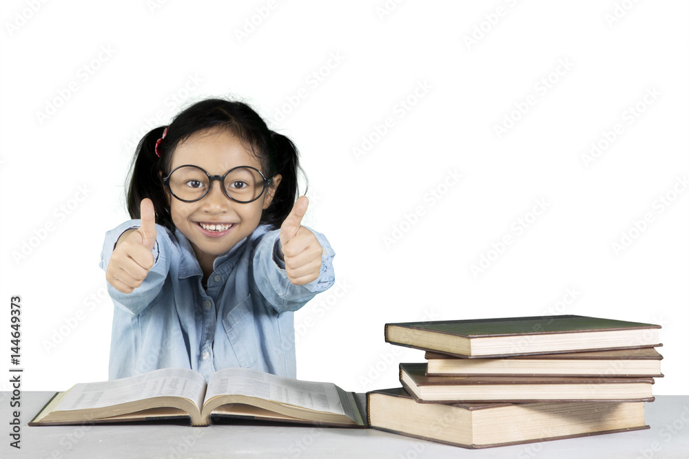 Primary student showing ok gesture with books Primary student showing ok gesture with books
