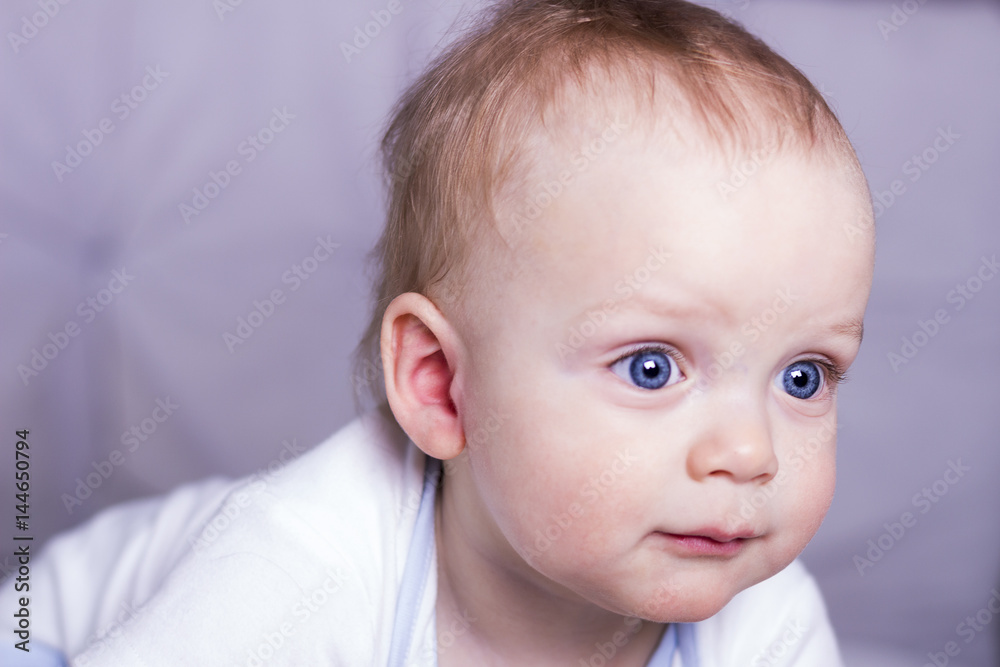 Blue-eyed 111 month baby boy. Calm serious infant kid close-up portrait.