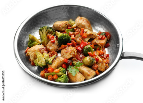 Chicken stir fry with vegetables in pan on white background