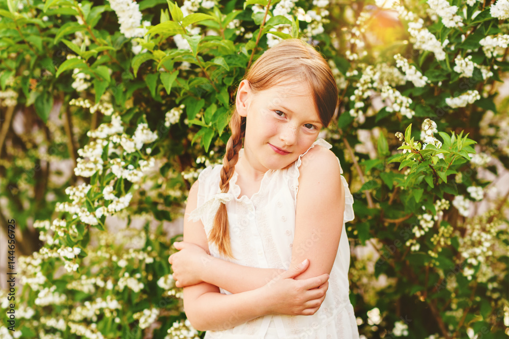 Little girl in the summer garden at sunset Little girl in the summer garden at sunset
