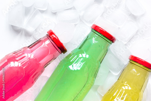 cold drinks in plastic bottles with ice white background top view mockup