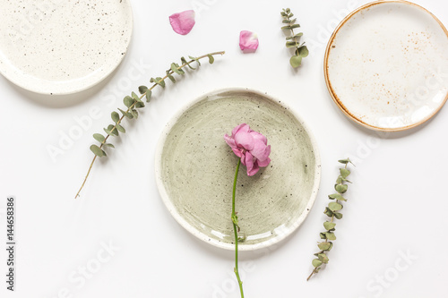 rose, eucalyptus and plates in spring design white background top view mockup