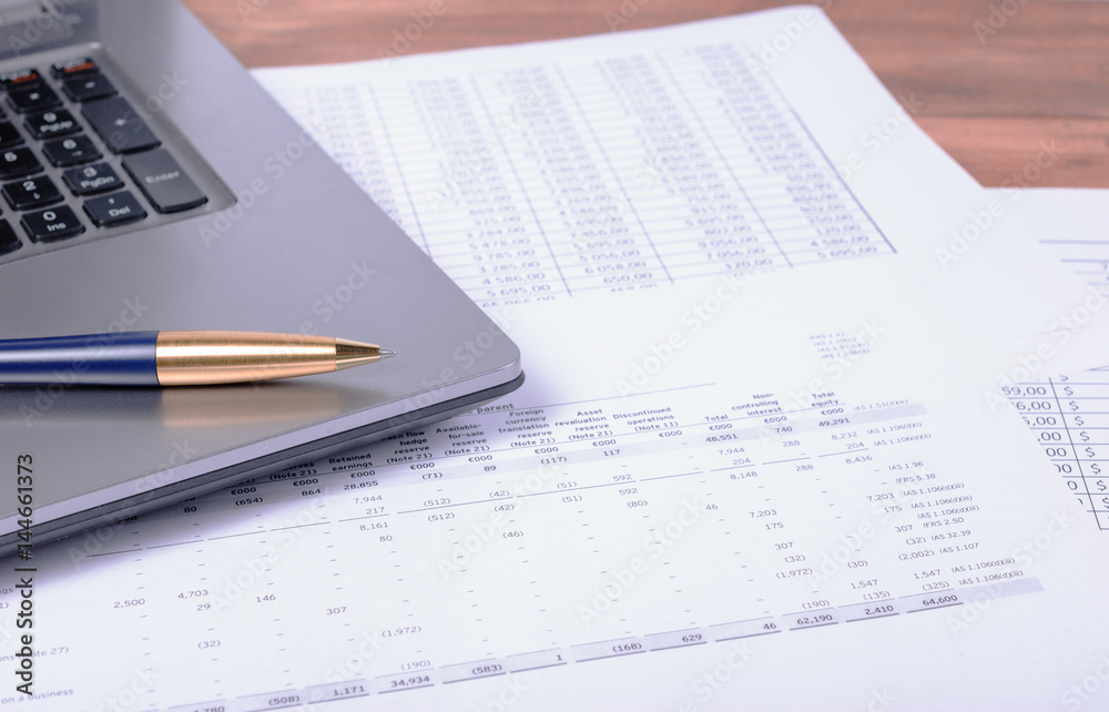 The notebook and pen lying on business papers The notebook and pen lying on business papers