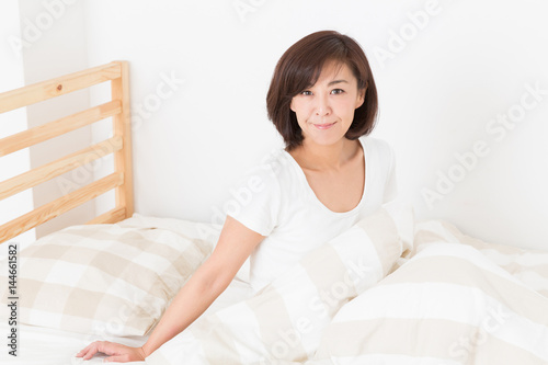 笑顔のミドル女性　ベッド