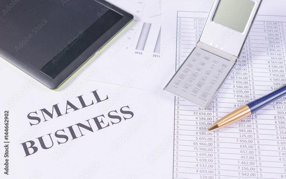 Tablet, calculator and pen on a business charts Tablet, calculator and pen on a business charts