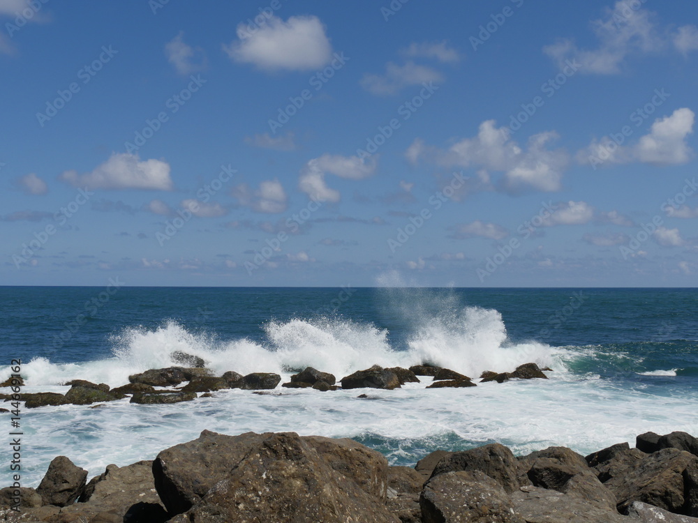 great waves against rocks  white foaming waves crash against rocks creating huge showers