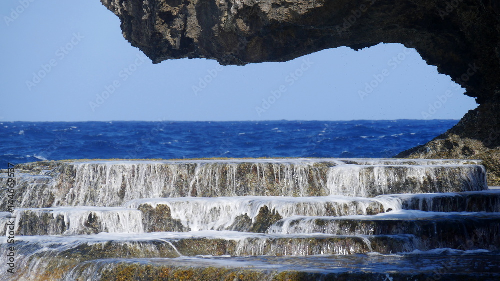 Rock platform at the Hidden Beach, Saipan Water flows over the rock ...