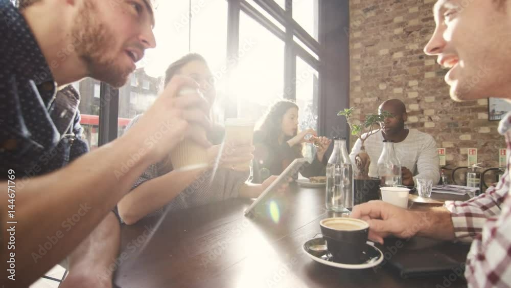  Happy group of friends chatting & having drinks in city coffee shop