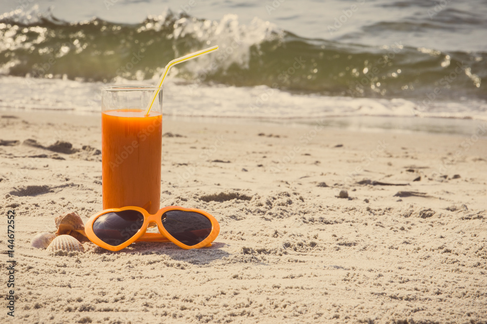 Vintage photo, Carrot juice and sunglasses at beach, concept of vitamin A and beautiful, lasting tan