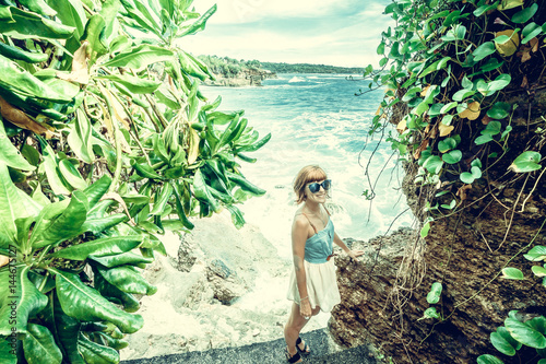 Portrait of happy young woman, tropical ocean view. Travel and Vacation. Outdoor shot. Nusa Lembongan, Bali, Indonesia.