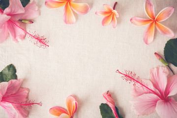 Pink and orange summer flowers on linen copy space background