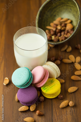 Tasty macaroons and cup of milk with almond on wooden background Selective focus.