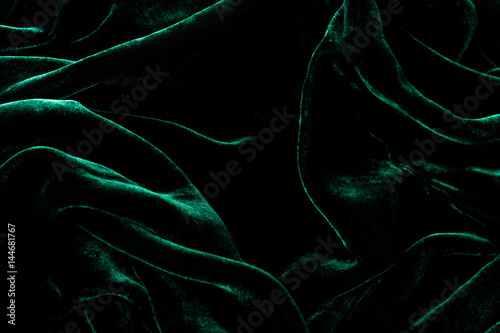 Dark green velvet background. Luxurious shiny material. photo