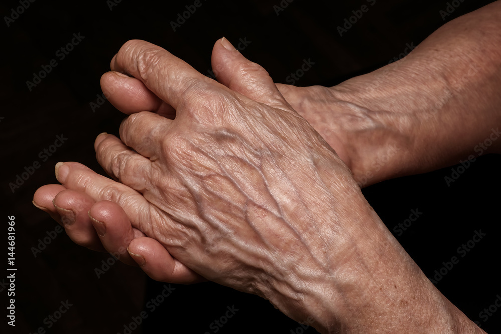 Folded senior woman wrinkled hands close up. Old age, age problems, poverty and loneliness theme Folded senior woman wrinkled hands close up. Old age, age problems, poverty and loneliness theme
