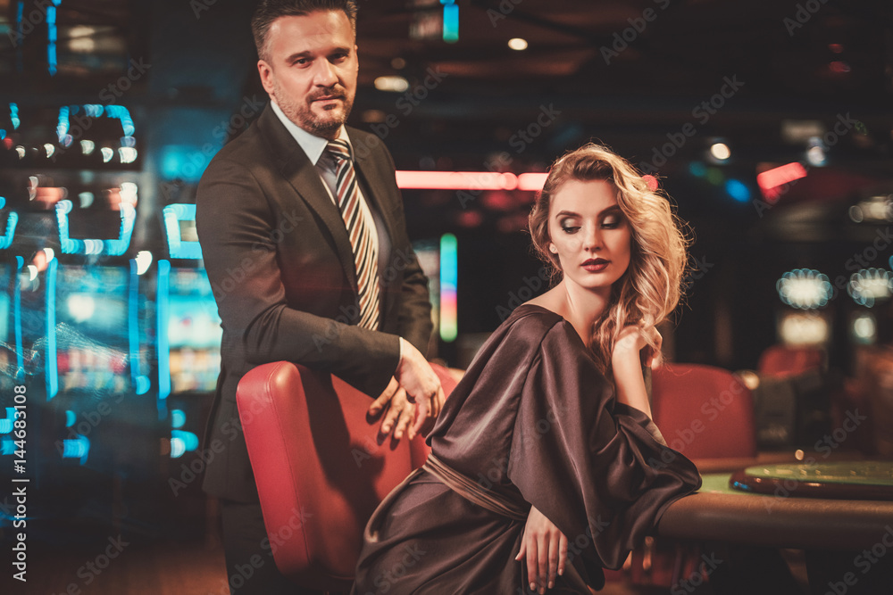 Well-dressed couple in a luxury casino interior Well-dressed couple in a luxury casino interior