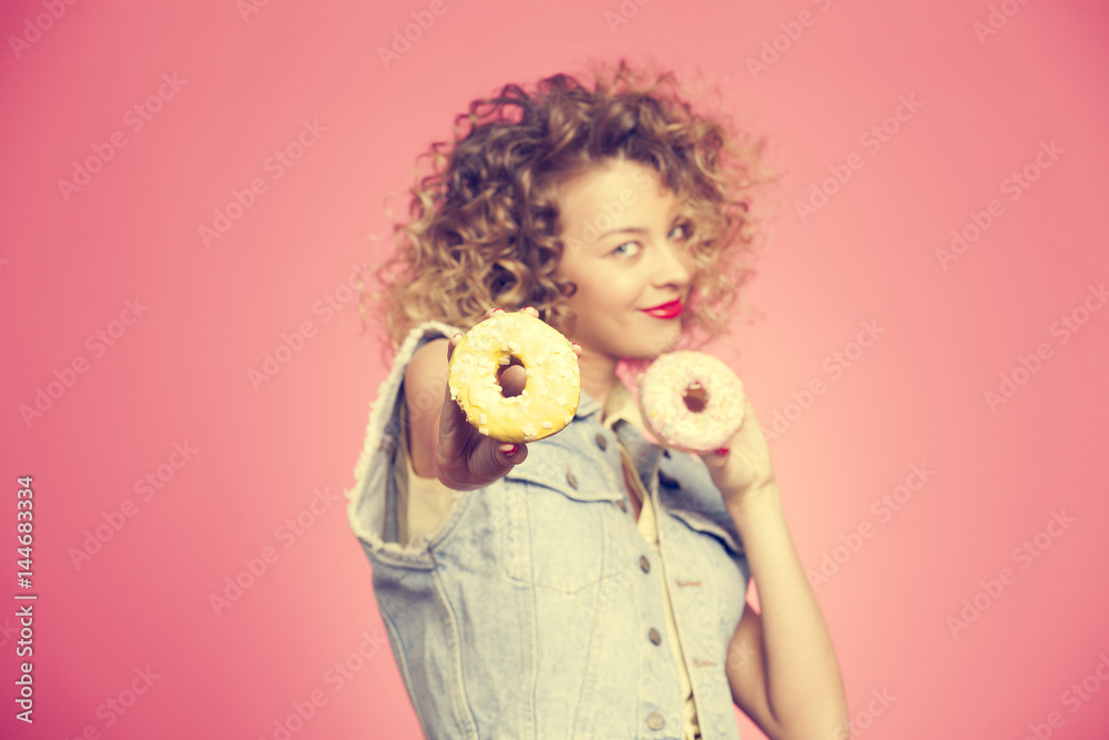 the hand of the girl with the donuts on pink background the hand of the girl with the donuts on pink background