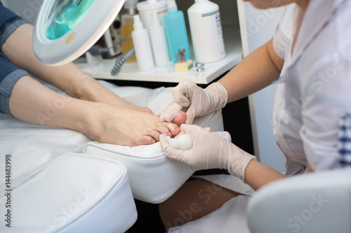 Pedicure dead skin remover foot rasp woman in nail salon. Application of the cream © Artem Zakharov