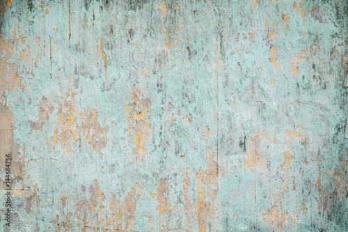 Weathered, faded and peeled off turquoise concrete wall texture background with vignetting.