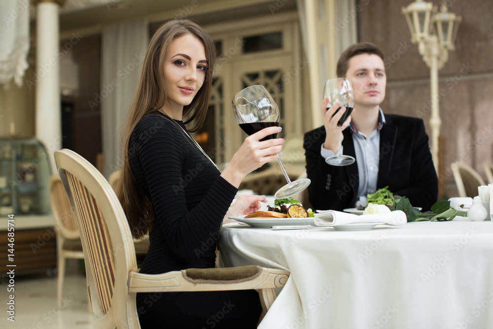 Beautiful woman and man in restaurant, holding glass of wine Beautiful woman and man in restaurant, holding glass of wine