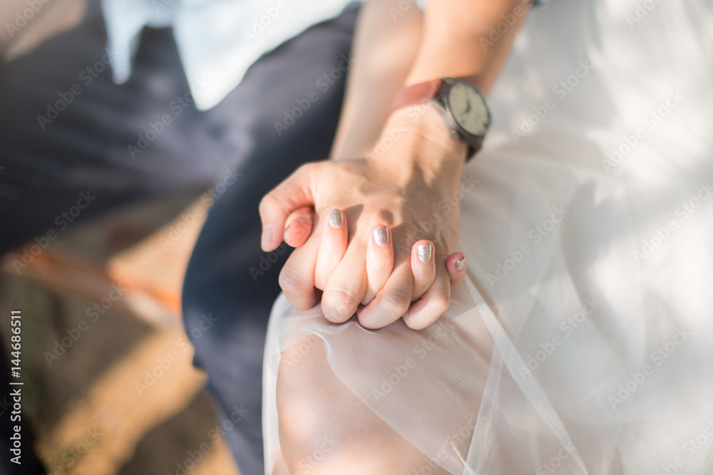 Closeup of woman and man holding hands together