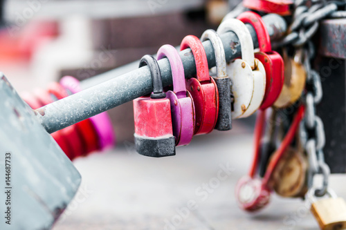 Six padlocks on the pipe. Old, rusty. Blurred background, chain, bridge.