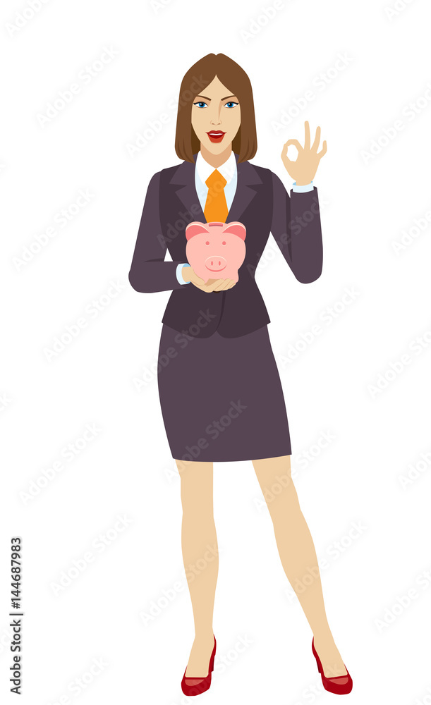 Businesswoman holding a piggy bank and showing a okay hand sign Businesswoman holding a piggy bank and showing a okay hand sign
